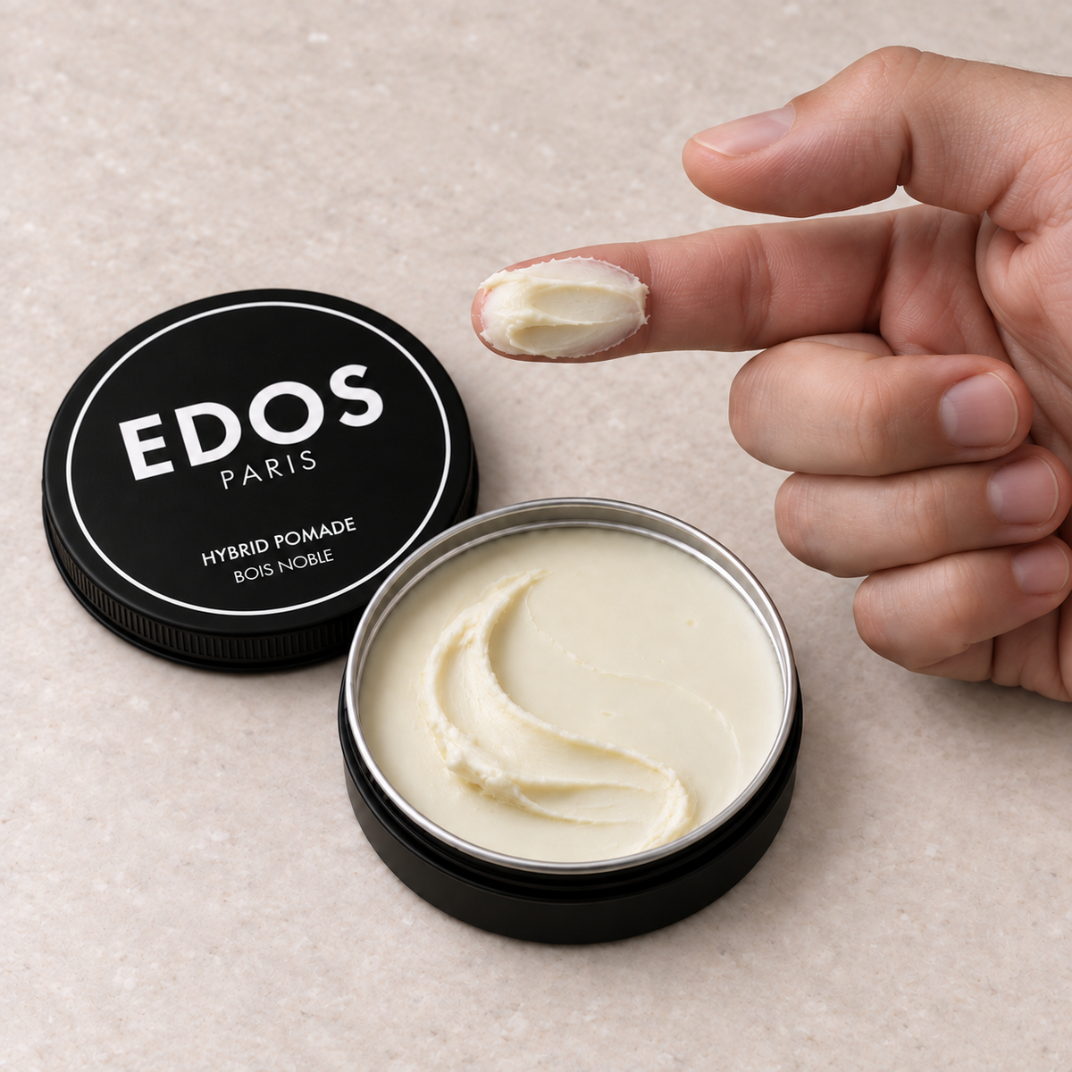 Hybrid Pomade EDOS Paris, dose de pommade étalée sur l’index près du pot ouvert.